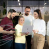 A bunch of people looking at laptop screen and discussing