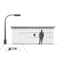 A man standing in a parking lot next to the Cleveron 355 outdoor parcel locker for oversized goods, mimicking the machine's height. Adjacent to the locker is an electrical post, and the machine is positioned within the parking lot.